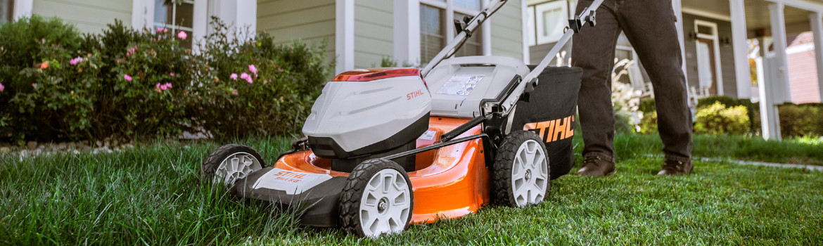 Person pushes a walk behind 2019 Stihl® lawn mower in the front yard